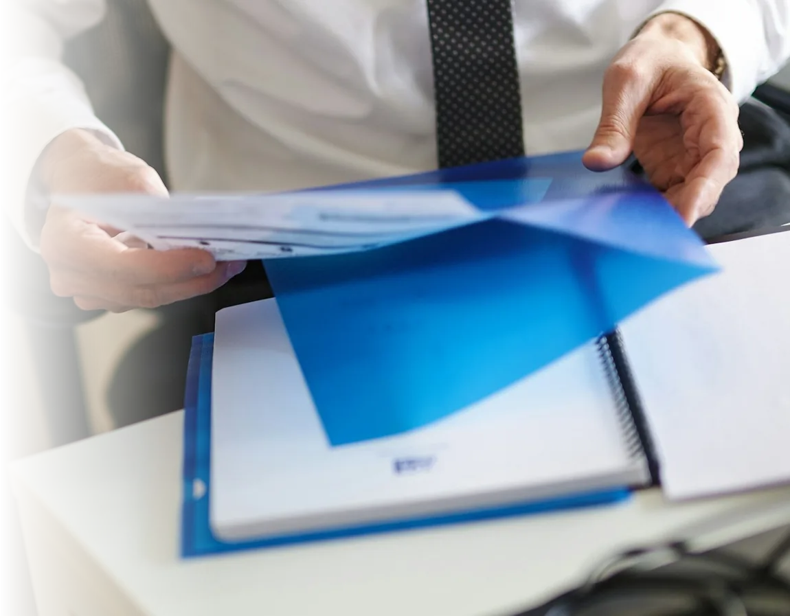 Manos entregando una carpeta con un informe; guía de la fiscalización de la Superintendencia de Educación en convivencia