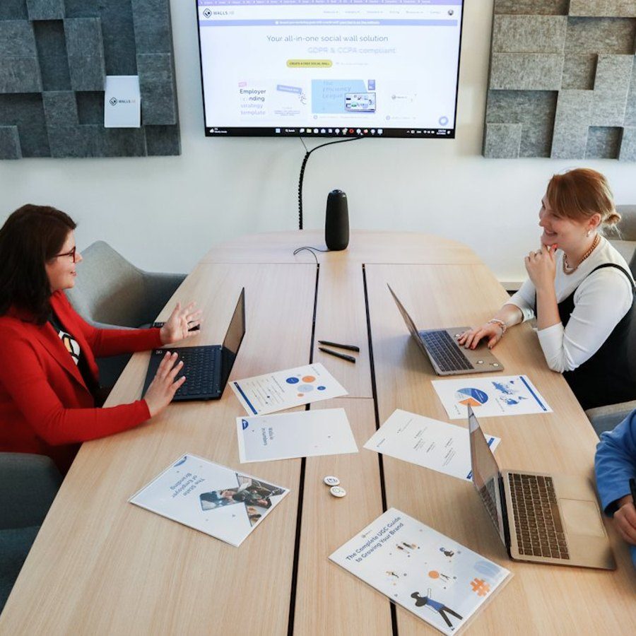 Equipo trabajando en una mesa con computadores y documentos