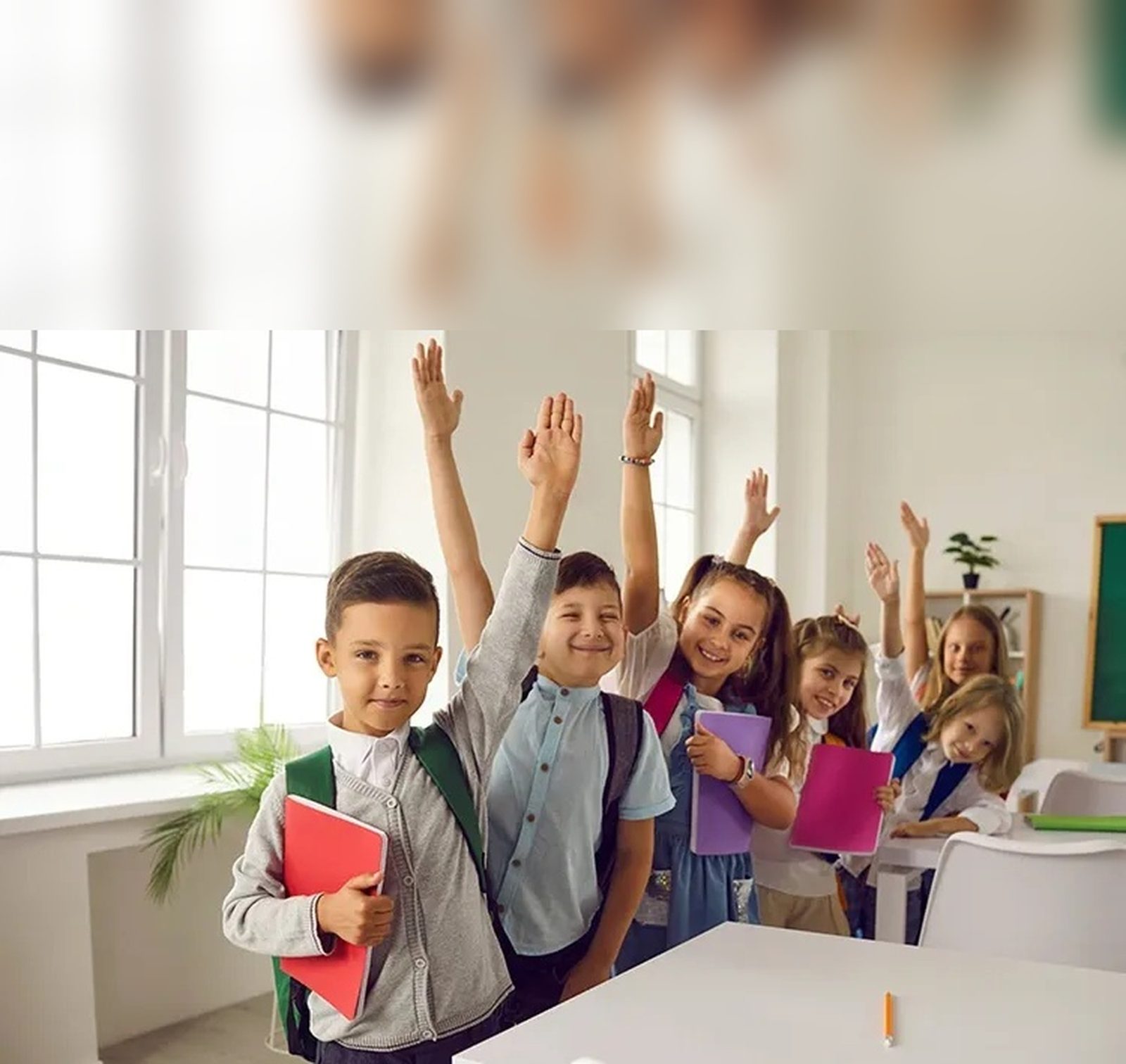 Niños en una sala de clases levantando la mano