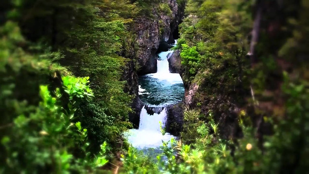 Cascada entre bosque verde en el Parque Nacional Radal Siete Tazas, Región del Maule